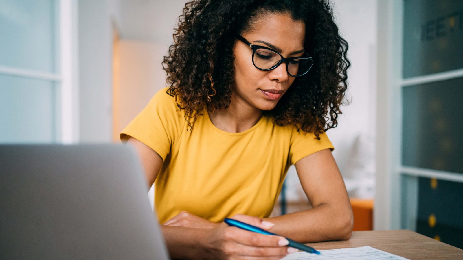 Business woman sat at desk drafting with pen and paper