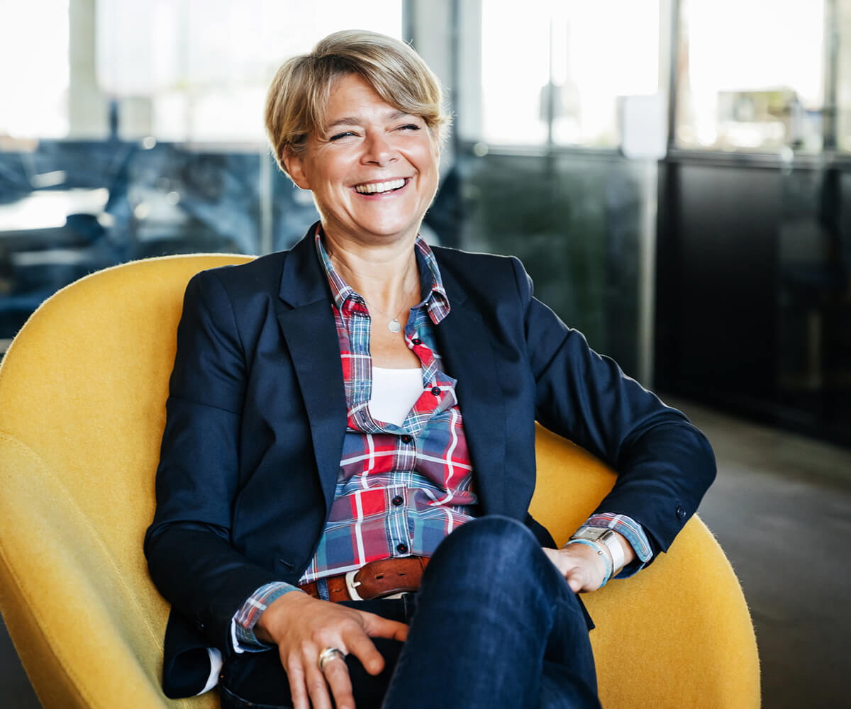 Business woman sat in chair smiling