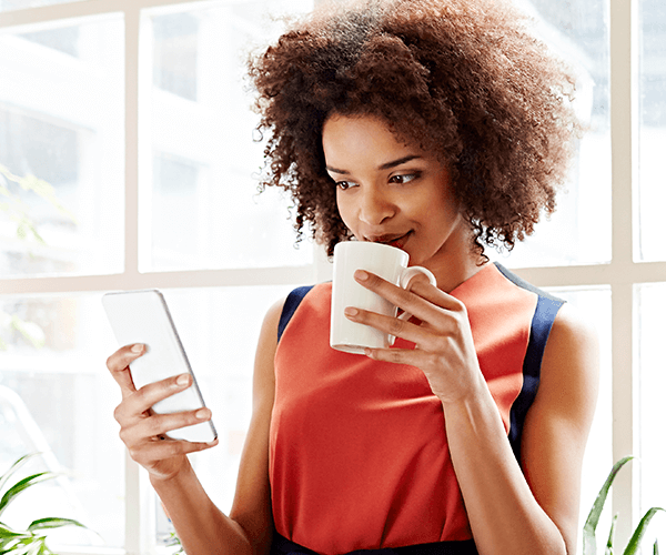 Person on phone looking at newsletter